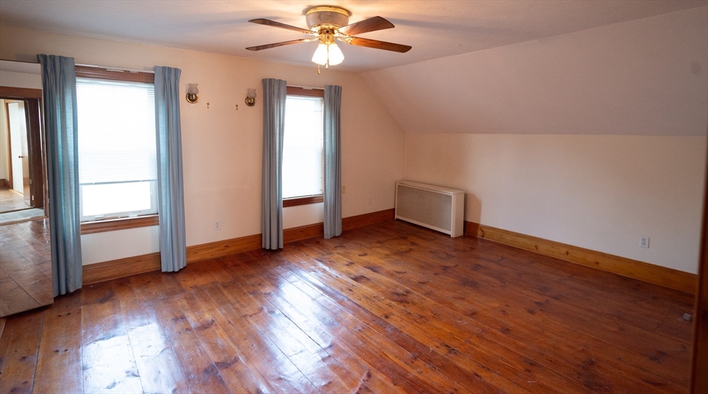 4 Winter Street Clinton, MA 01510 - Photo 14 of 33 an empty room with wooden floor chandelier fan and windows