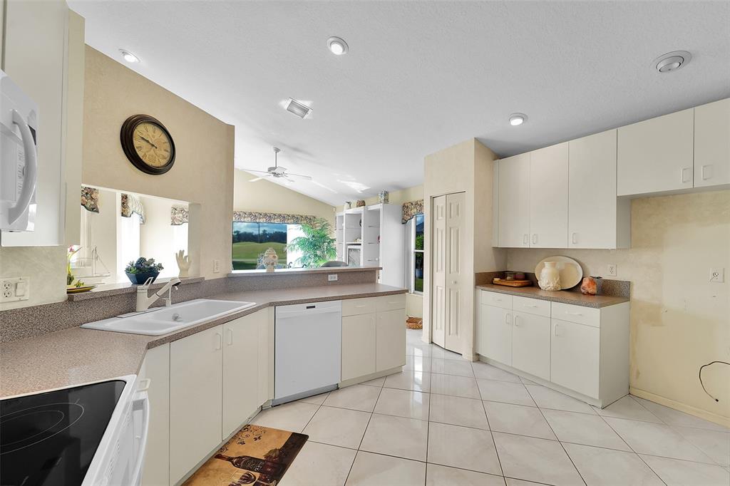 6898 Grenelefe Road Boynton Beach, FL 33437 - Photo 15 of 65 a kitchen with stainless steel appliances a sink a stove a refrigerator and cabinets