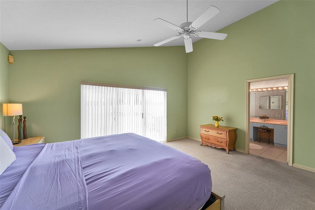 6898 Grenelefe Road Boynton Beach, FL 33437 - Photo 24 of 65 a bedroom with a bed and a chandelier