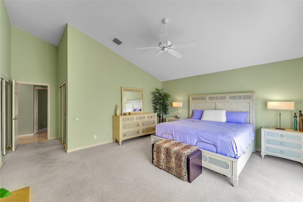 6898 Grenelefe Road Boynton Beach, FL 33437 - Photo 25 of 65 a bedroom with a bed and a chandelier