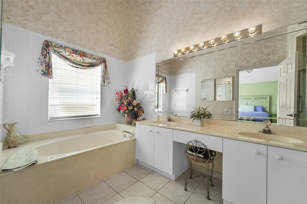 6898 Grenelefe Road Boynton Beach, FL 33437 - Photo 26 of 65 a bath room with a sink and a mirror