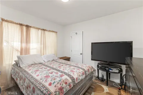 a bedroom with a bed and a flat screen tv