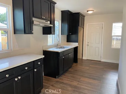 a kitchen with a sink a refrigerator and cabinets