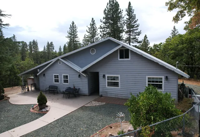 a view of a house with a yard and trees in the background