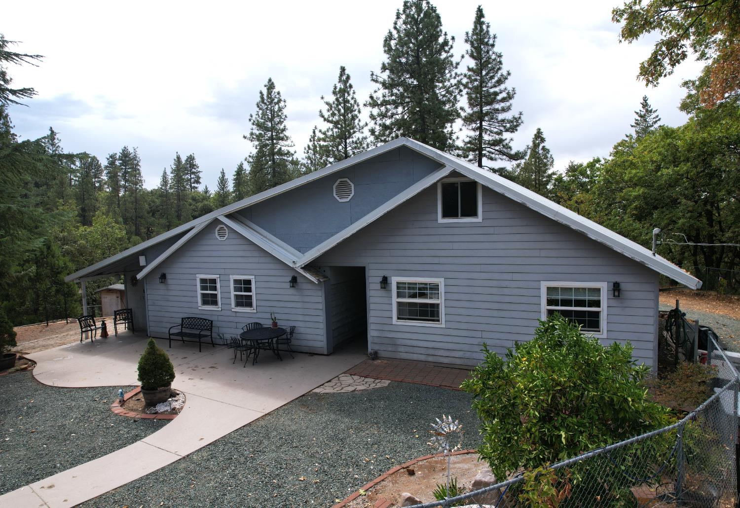 a view of a house with a yard and trees in the background