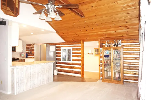 a view of a hallway with wooden floor and cabinet with a living room