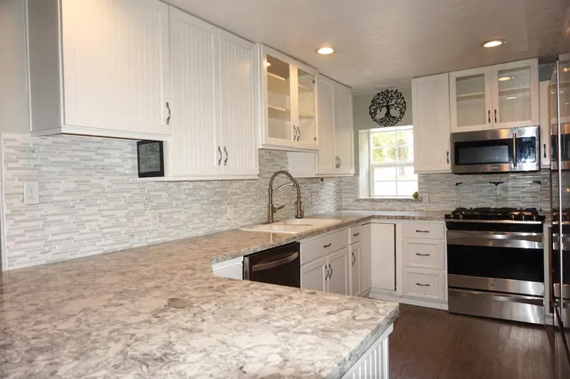 a kitchen with a sink and a stove top oven