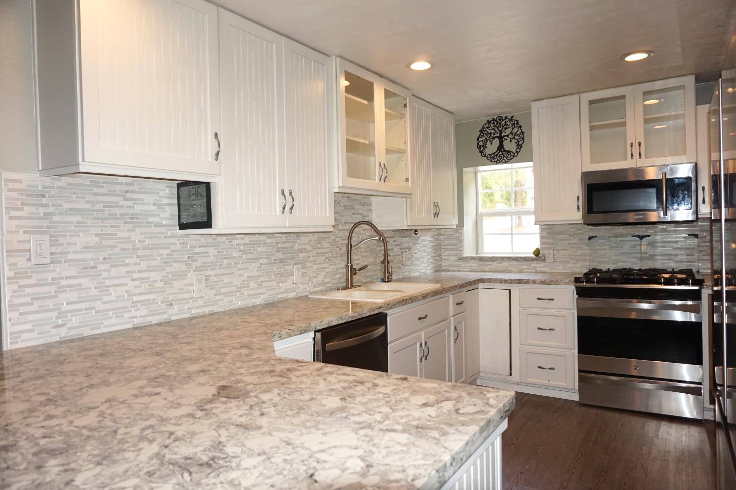 20480 Timber Ridge Road Pine Grove, CA 95665 - Photo 20 of 56 a kitchen with granite countertop a stove a sink and a microwave