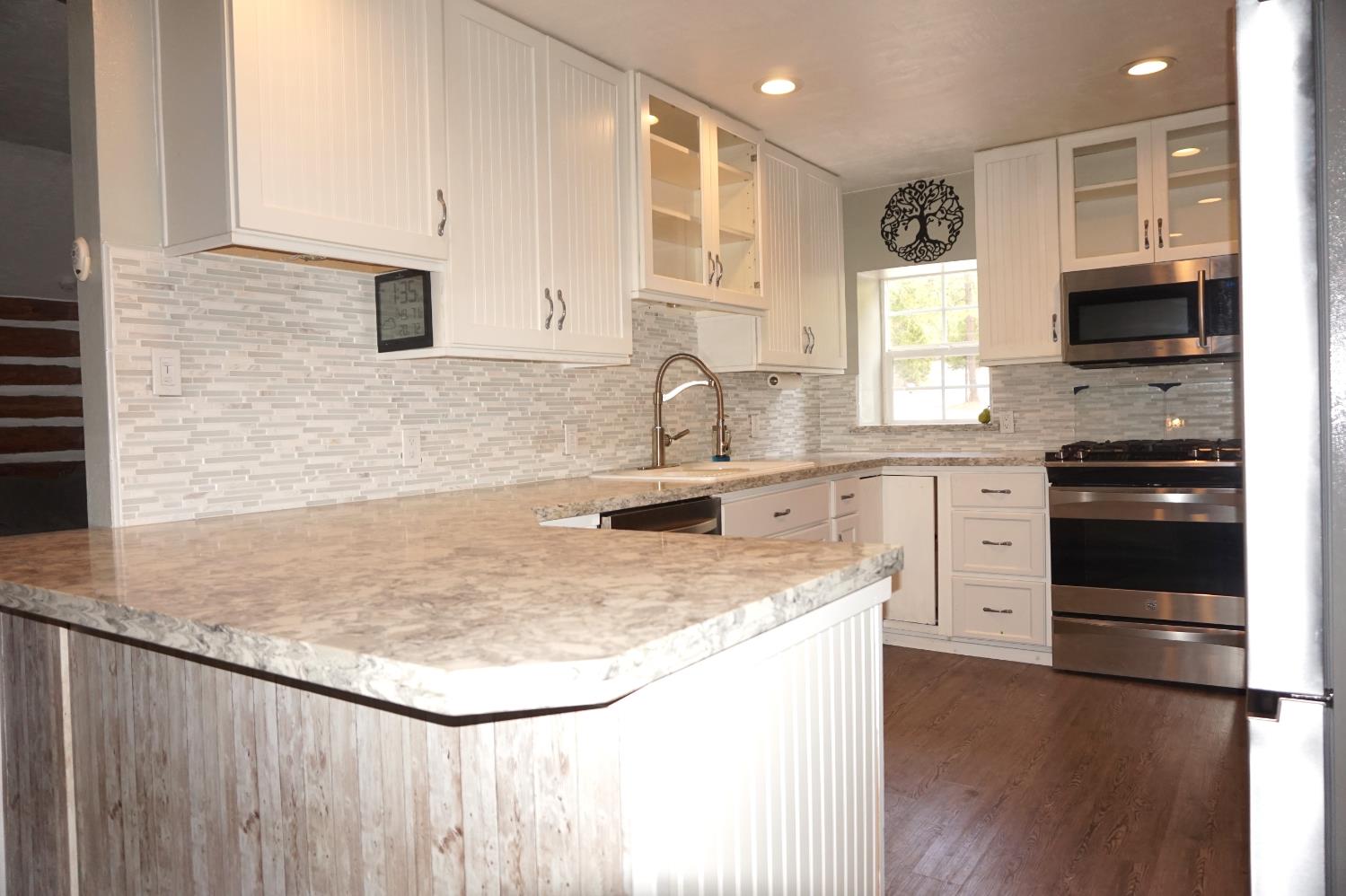 20480 Timber Ridge Road Pine Grove, CA 95665 - Photo 21 of 56 a kitchen with granite countertop a sink a stove and cabinets