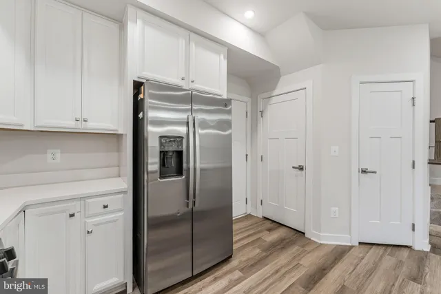 a view of kitchen with refrigerator and cabinets