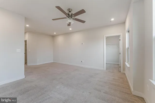 an empty room with a ceiling fan and a window