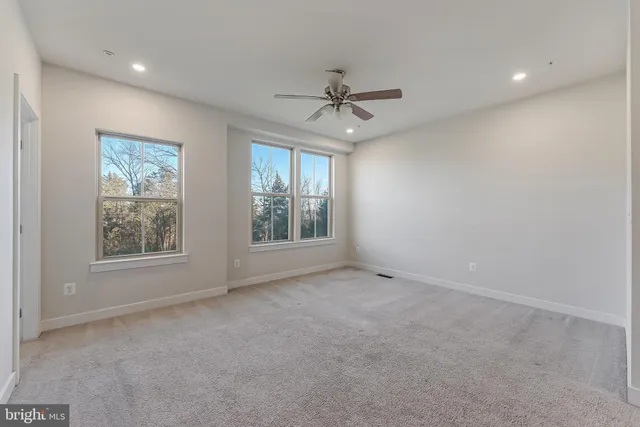 an empty room with a window and a fan