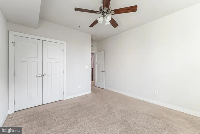 an empty room with chandelier fan