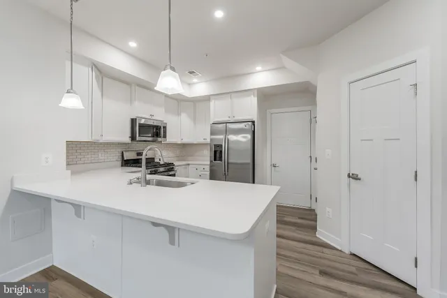 a kitchen with a refrigerator a sink and microwave