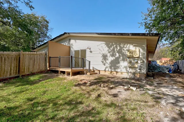 a view of backyard with deck and seating space