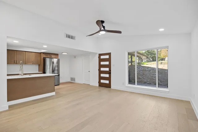a view of an empty room with window and cabinet