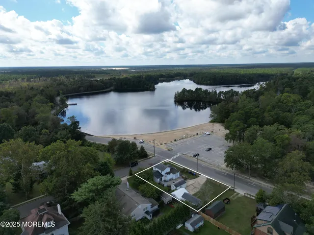 an aerial view of a house with a yard and lake view