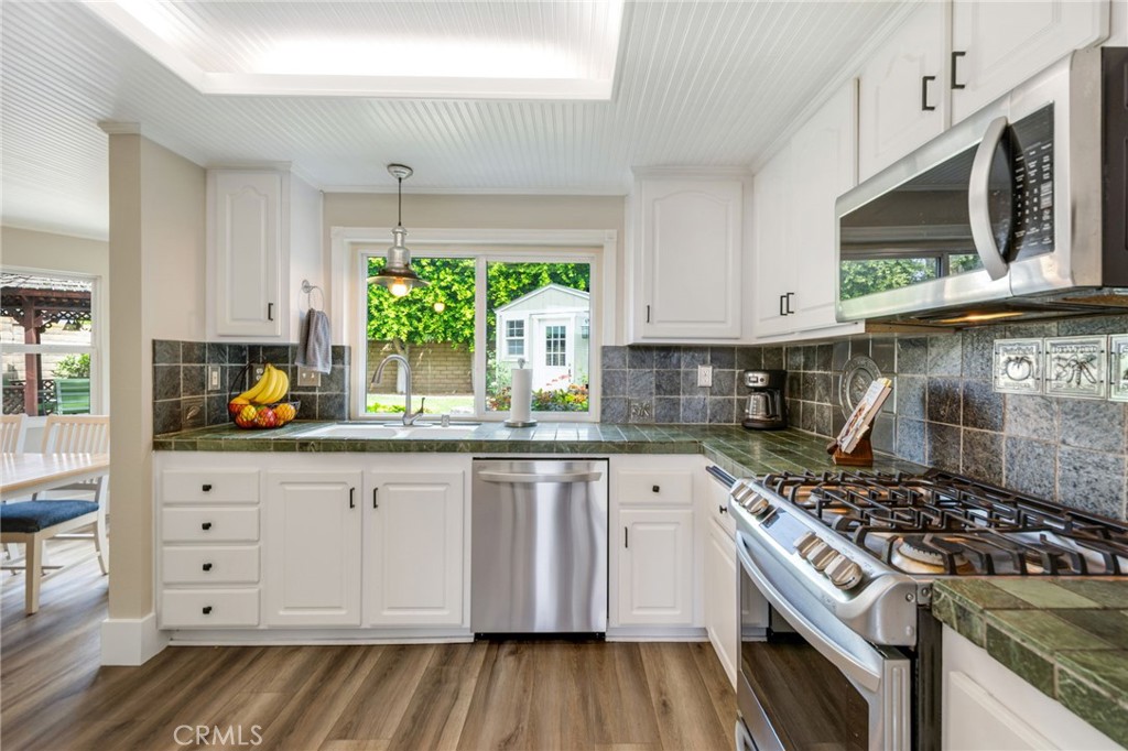 109 Cinnamon Ridge Road Brea, CA 92821 - Photo 19 of 67 Remodeled kitchen including brushed marble countertop tiles, dual sink and window view to back yard, stainless steel appliances and cabinetry and drawers for storage.