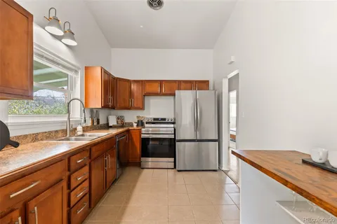 a kitchen with granite countertop a refrigerator and a sink