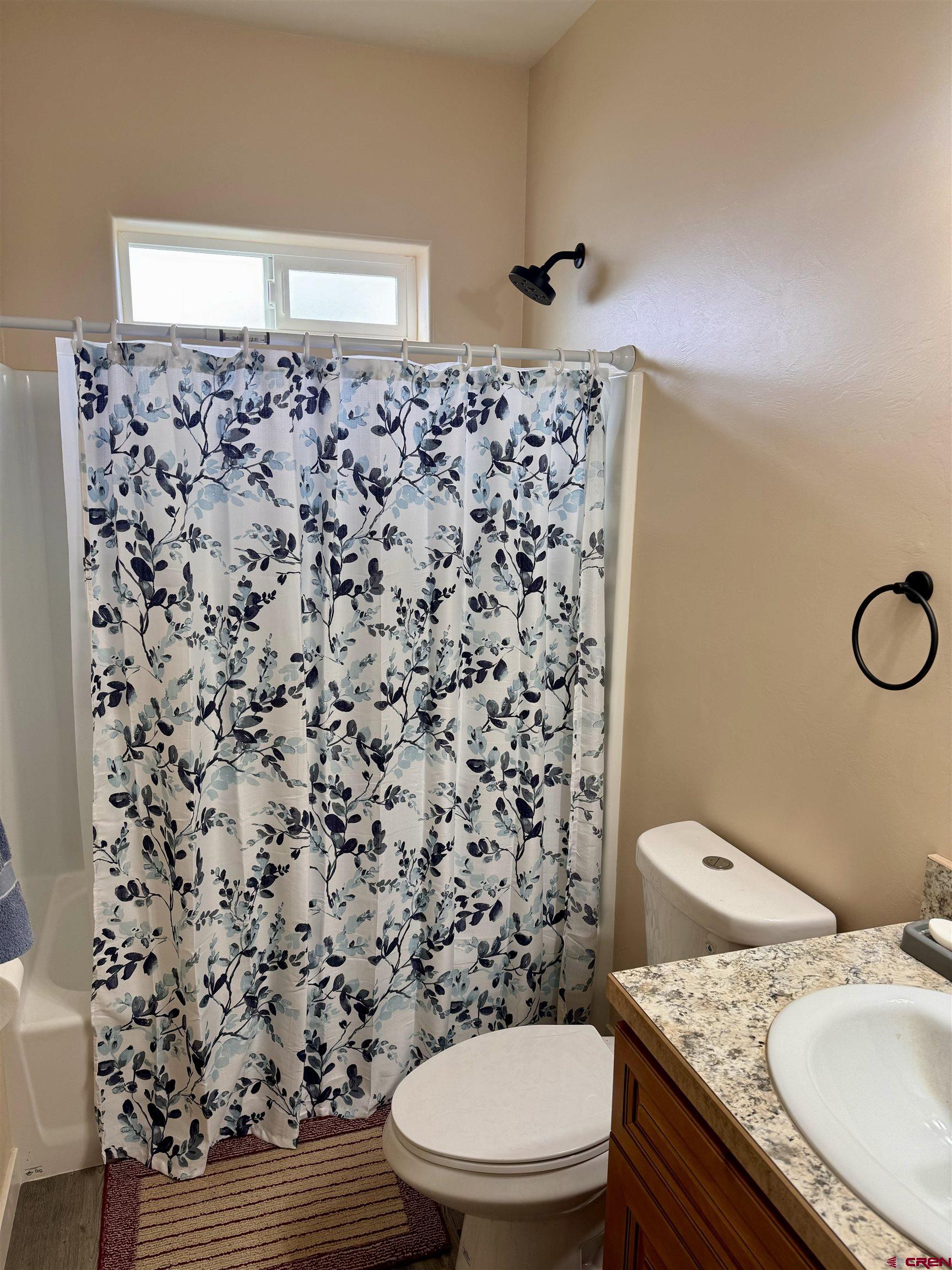 23184 D50 Road Delta, CO 81416 - Photo 17 of 23 a bathroom with a granite countertop toilet a sink and a mirror