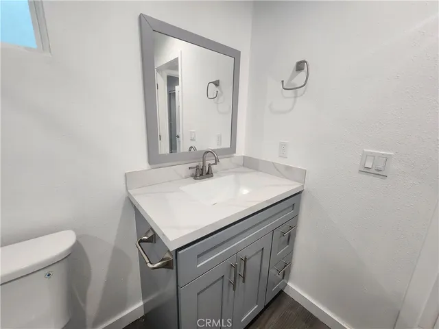 a bathroom with a sink vanity and a toilet