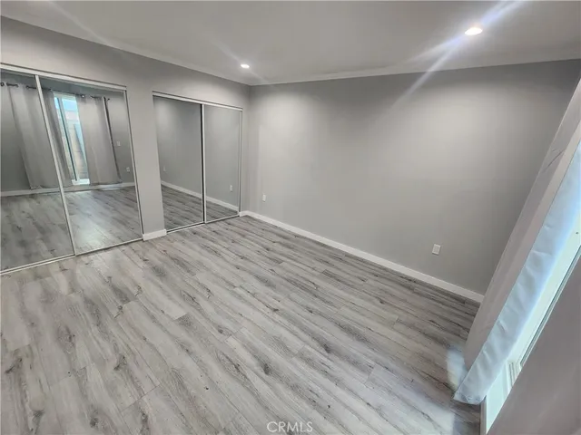 an empty room with wooden floor and mirror