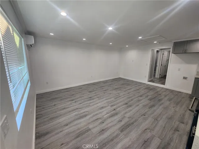 an empty room with wooden floor and entrance