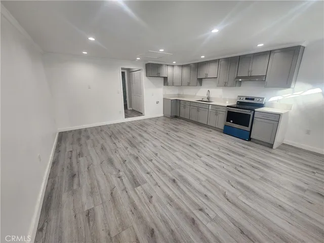 a kitchen with stainless steel appliances granite countertop a wooden floors and white walls
