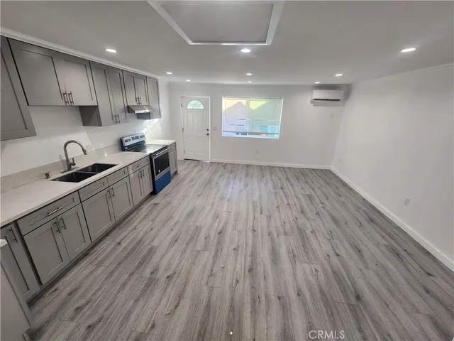 a kitchen with kitchen island wooden floors wooden cabinets and stainless steel appliances