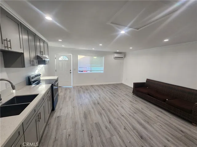 a kitchen with stainless steel appliances granite countertop a sink a stove and a wooden floors