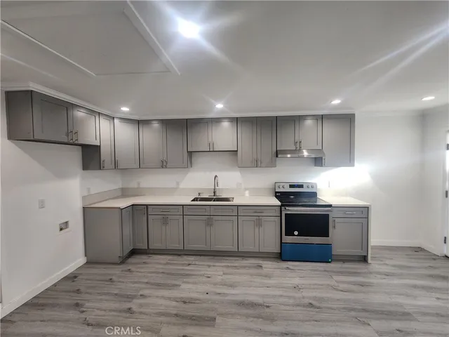 a large kitchen with stainless steel appliances granite countertop a stove and a sink