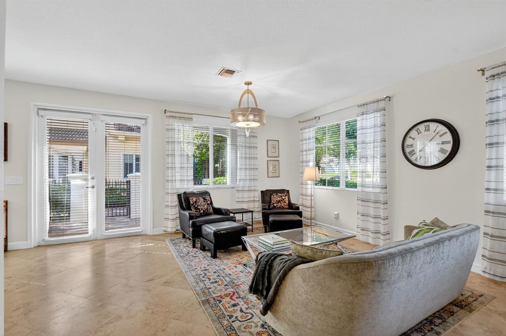 591 Northwest Library Commons Way Boca Raton, FL 33432 - Photo 20 of 75 a living room with furniture a large window and a clock