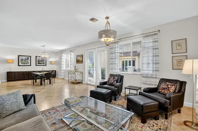 a view of a hallway with wooden floor and a living room