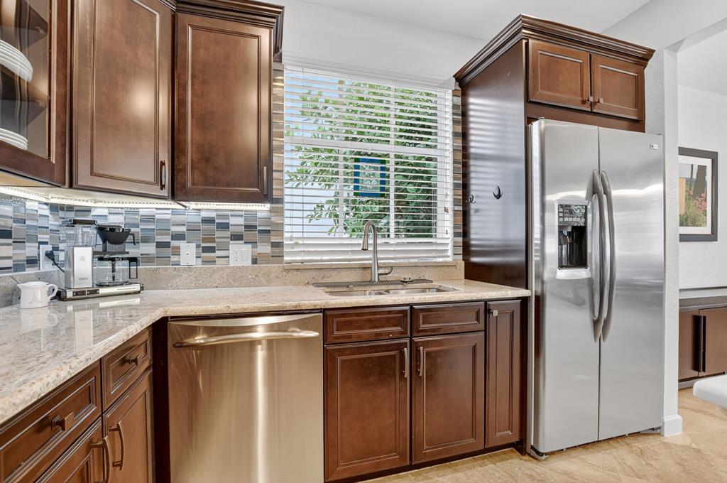 591 Northwest Library Commons Way Boca Raton, FL 33432 - Photo 32 of 75 a kitchen with stainless steel appliances granite countertop a refrigerator and a sink