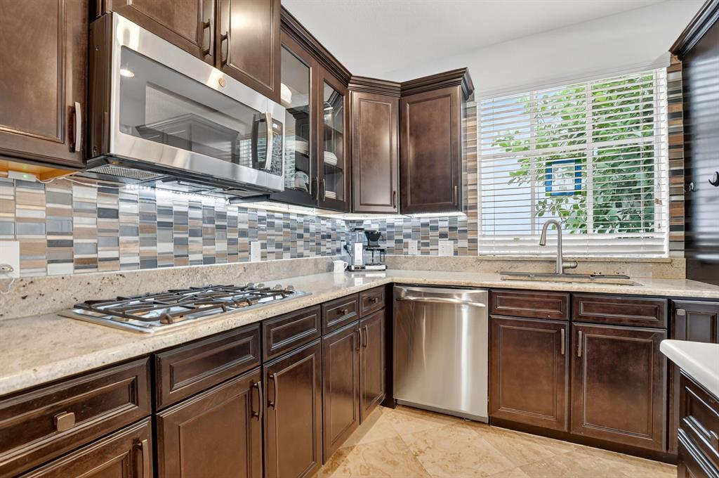 591 Northwest Library Commons Way Boca Raton, FL 33432 - Photo 33 of 75 a kitchen with stainless steel appliances granite countertop a sink stove and cabinets