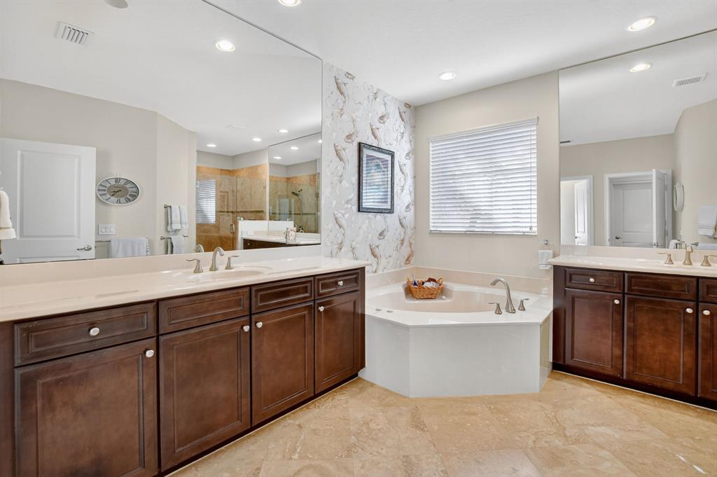591 Northwest Library Commons Way Boca Raton, FL 33432 - Photo 46 of 75 a spacious bathroom with a tub a sink double vanity and a mirror