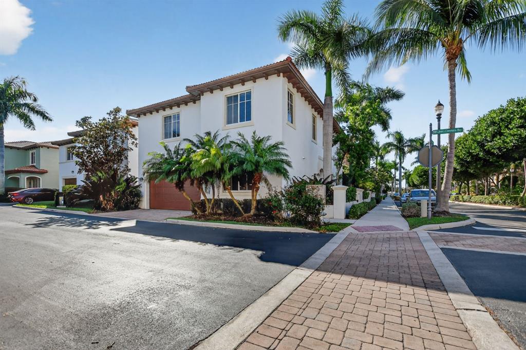 591 Northwest Library Commons Way Boca Raton, FL 33432 - Photo 9 of 75 front view of a house with a yard and palm trees