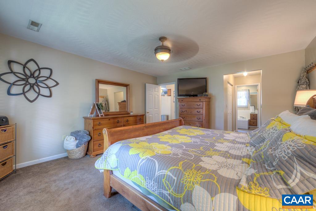 235 Spring Oaks Lane Ruckersville, VA 22968 - Photo 25 of 44 a bedroom with a bed and a flat tv screen on dresser