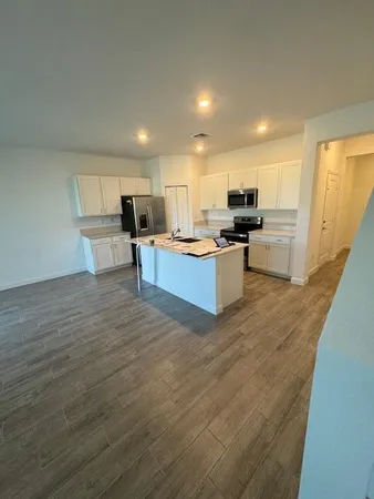 a kitchen with a sink cabinets and wooden floor