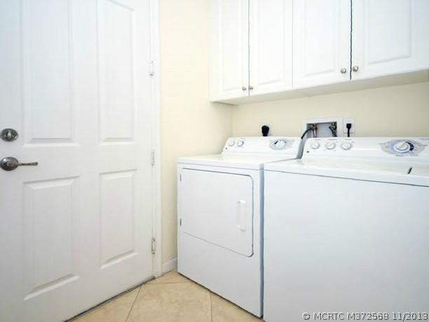 134 Southwest Walking Path Stuart, FL 34997 - Photo 23 of 25 Other. Laundry room with ample storage, tile flooring, convenient location off kitchen with pocket door, 42" white cabinetry, GE washer/dryer