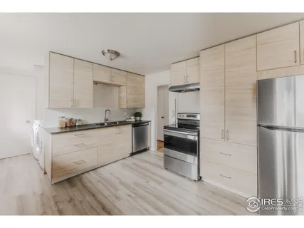 a kitchen with a refrigerator and a stove top oven