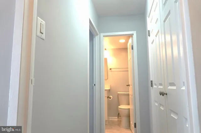 a bathroom with a granite countertop toilet a sink and a large mirror