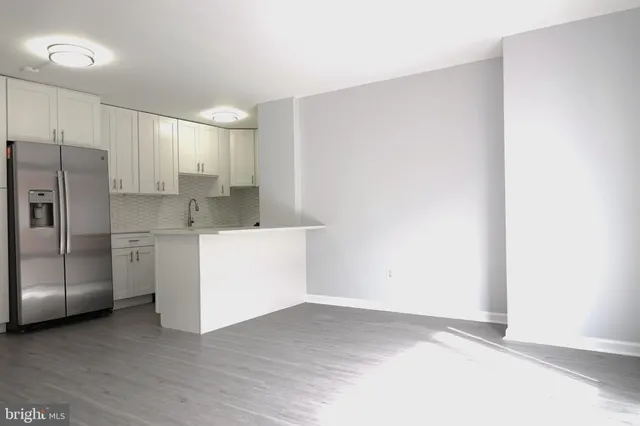 a view of a kitchen with white cabinets and stainless steel appliances