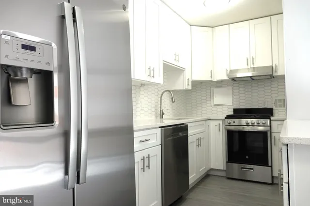 a kitchen with stainless steel appliances granite countertop a stove a sink and a refrigerator