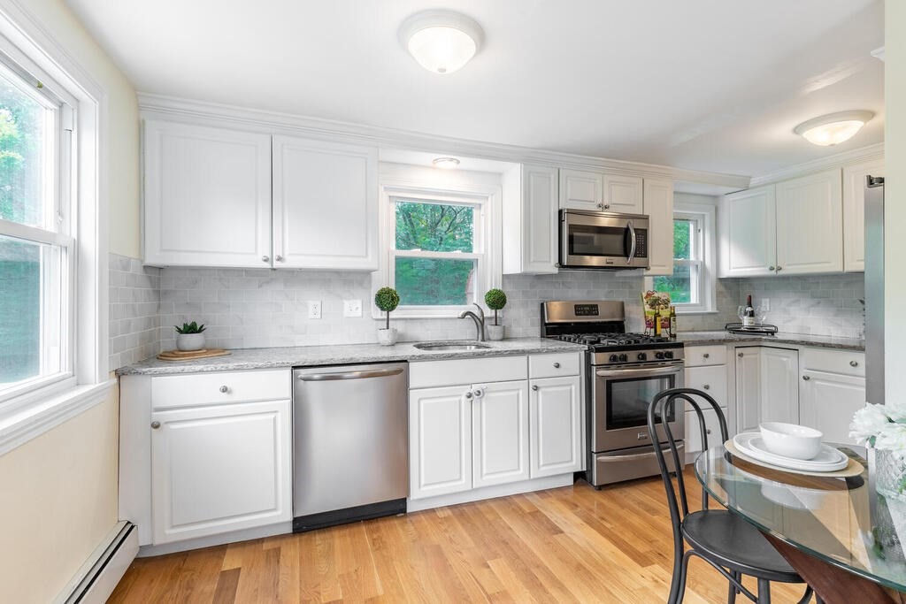 18 Woodbury Road Billerica, MA 01821 - Photo 11 of 30 a kitchen with granite countertop white cabinets and stainless steel appliances