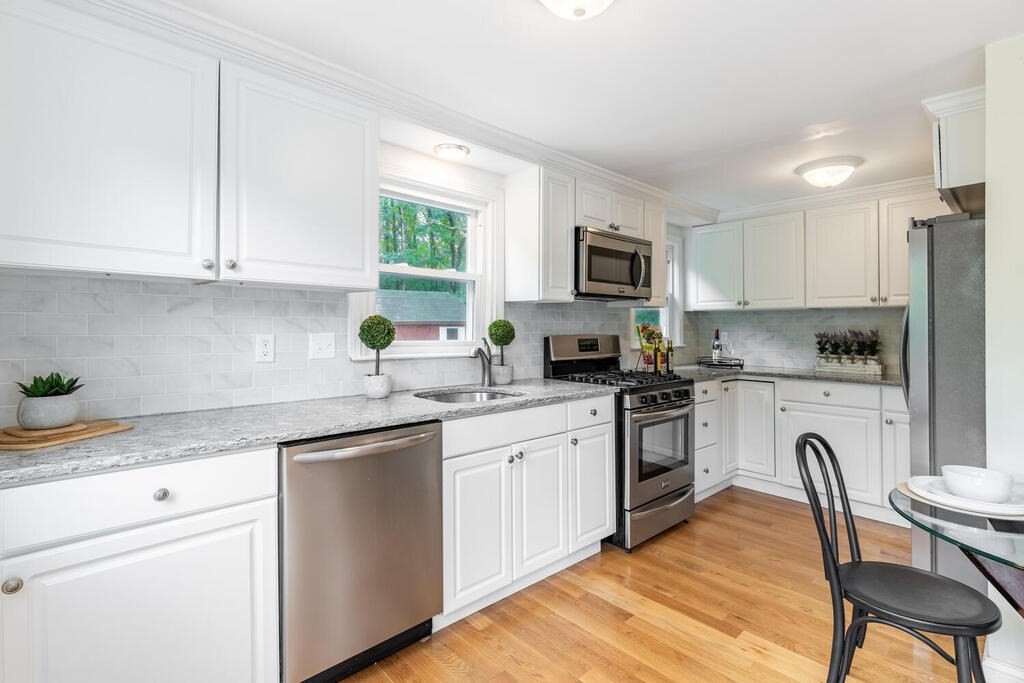 18 Woodbury Road Billerica, MA 01821 - Photo 13 of 30 a kitchen with granite countertop white cabinets and stainless steel appliances