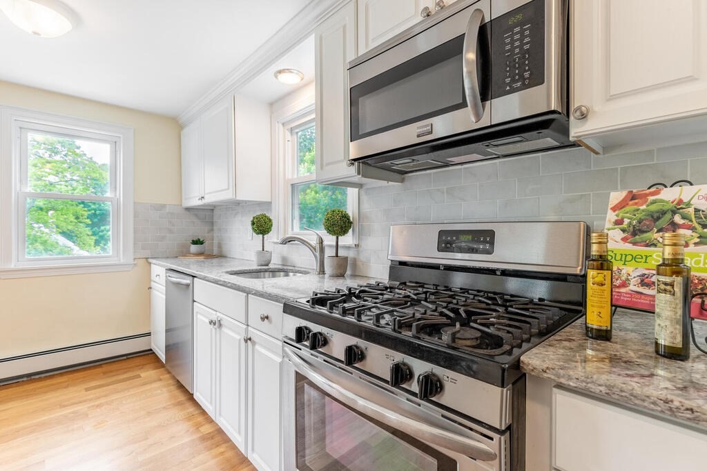 18 Woodbury Road Billerica, MA 01821 - Photo 15 of 30 a kitchen with stainless steel appliances granite countertop a stove a microwave cabinets and a sink