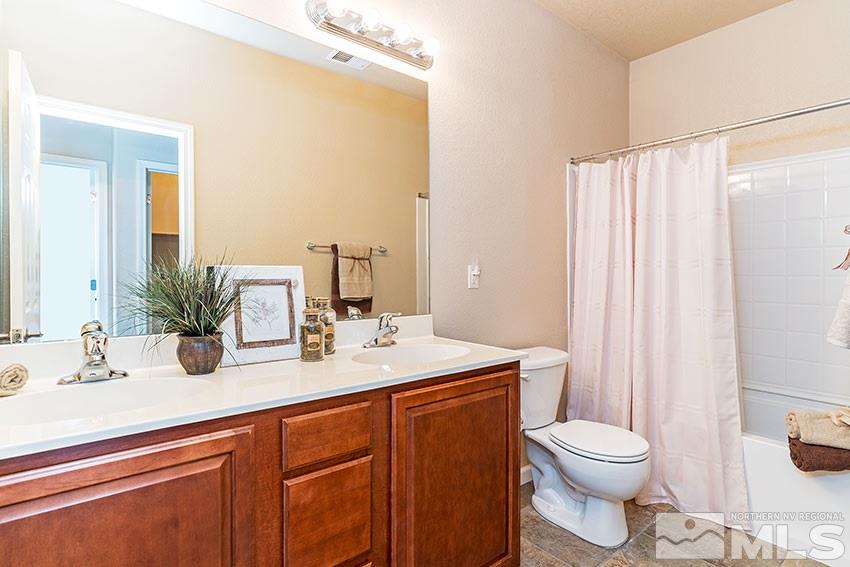 1815 Stetson Drive Reno, NV 89521 - Photo 16 of 20 a bathroom with a granite countertop sink a toilet and shower
