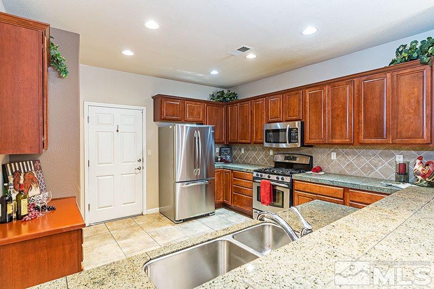 1815 Stetson Drive Reno, NV 89521 - Photo 2 of 20 a kitchen with stainless steel appliances granite countertop a refrigerator stove top oven and sink