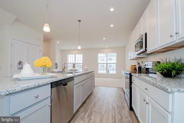 a kitchen with granite countertop kitchen island white cabinets and stainless steel appliances